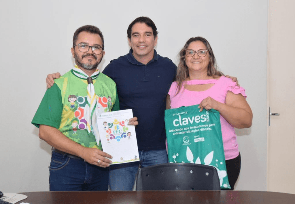 Representante do Grupo Escoteiro Maxwell Barros, prefeito de Assú e gestora do CEPA apresentam materiais do projeto Fortalecimento Familiar e Comunitário.