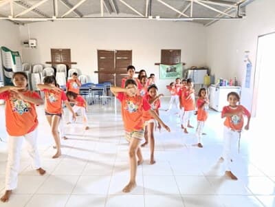 Crianças e educador participam de uma oficina de capoeira do projeto FFC.