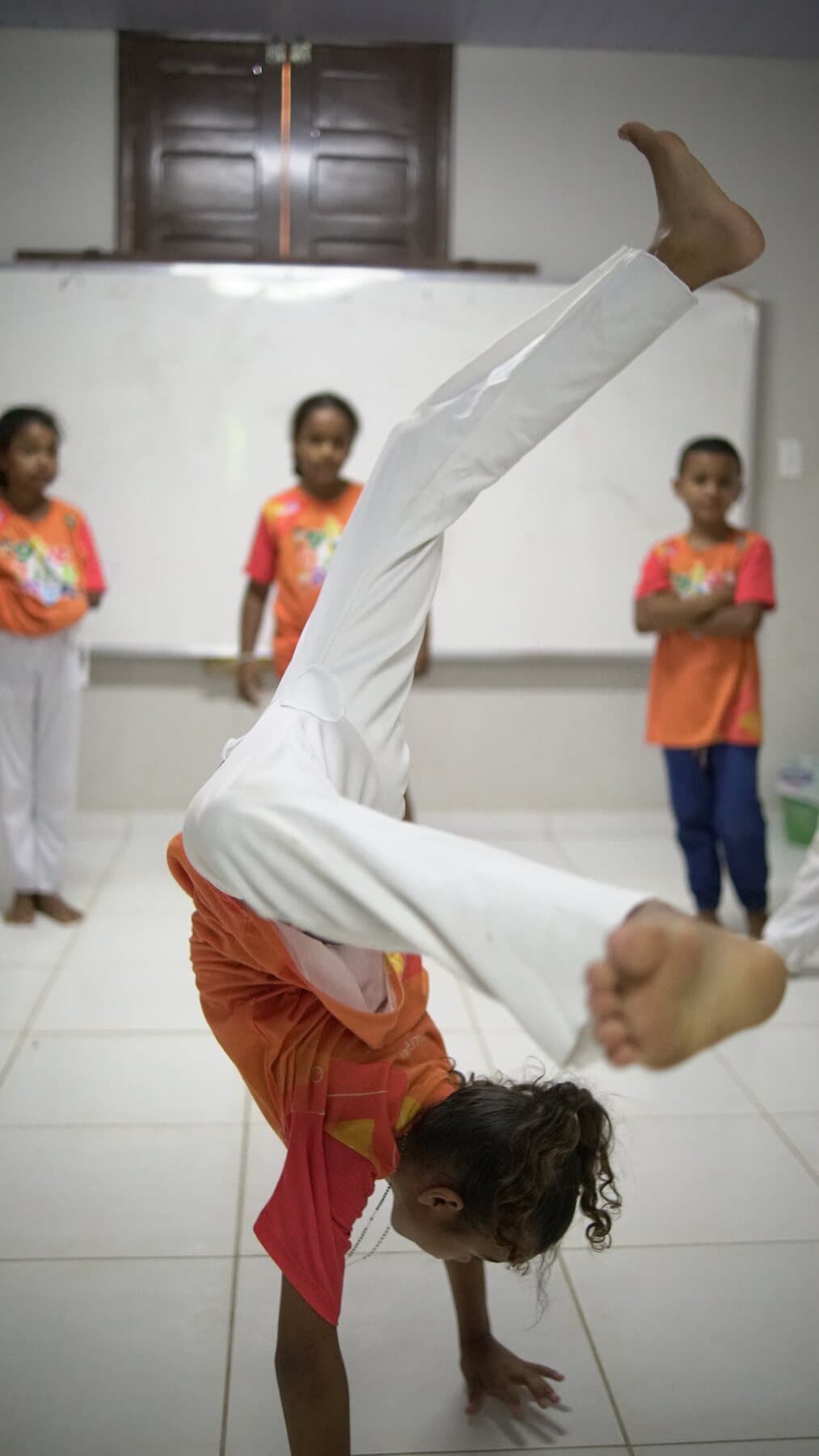 Capoeirista se movimenta diante das crianças durante oficina do FFC.
