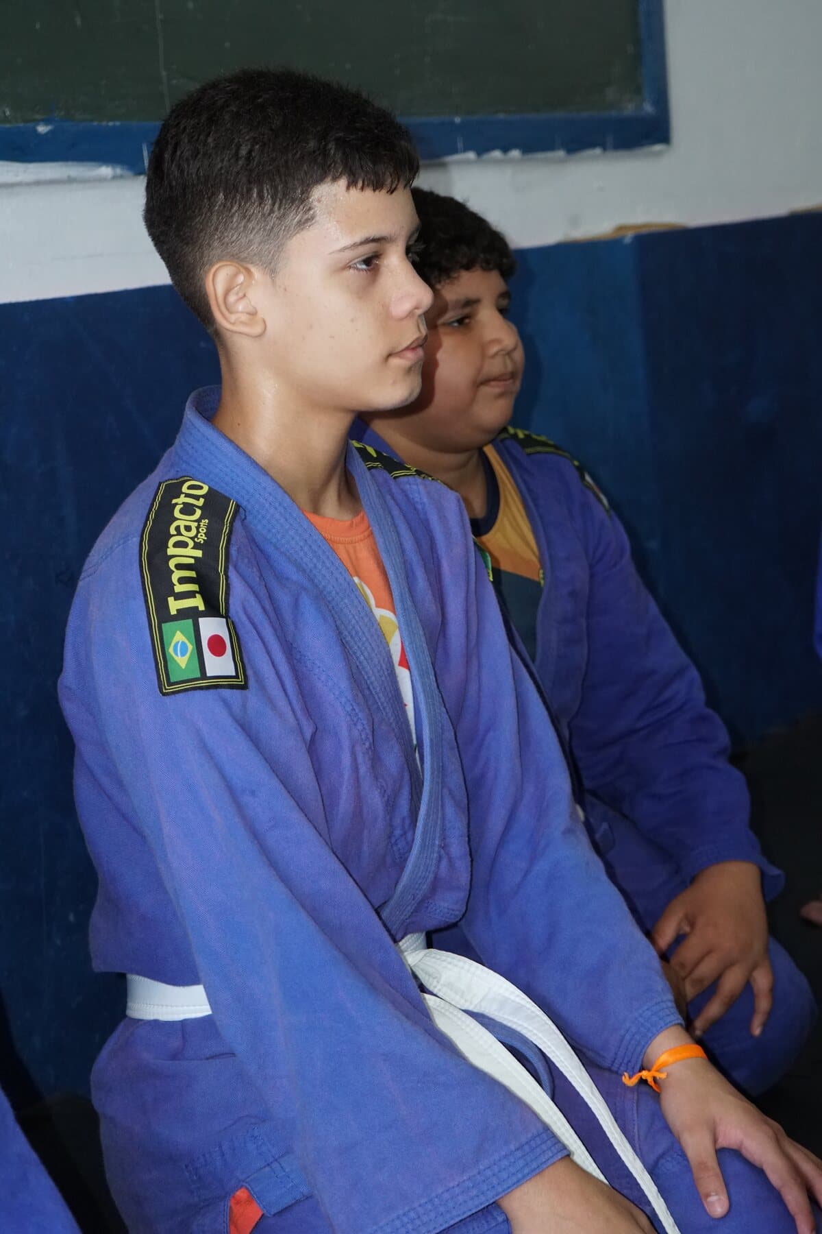 Crianças de quimono azul acompanham a oficina de judô do FFC.