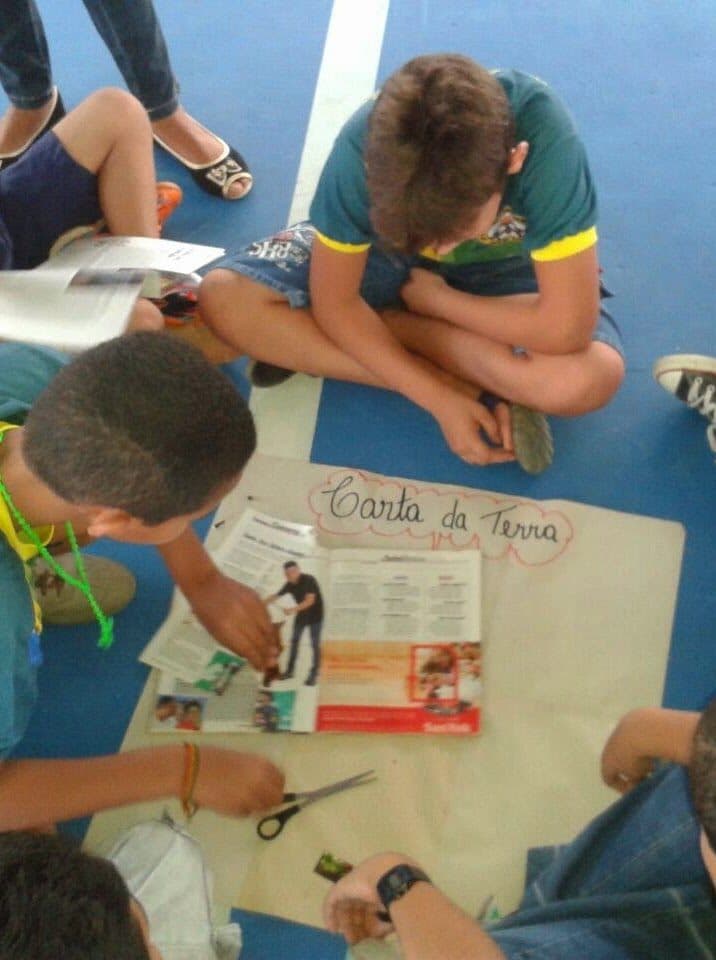 Crianças participam de uma oficina educativa acompanhadas por um adulto