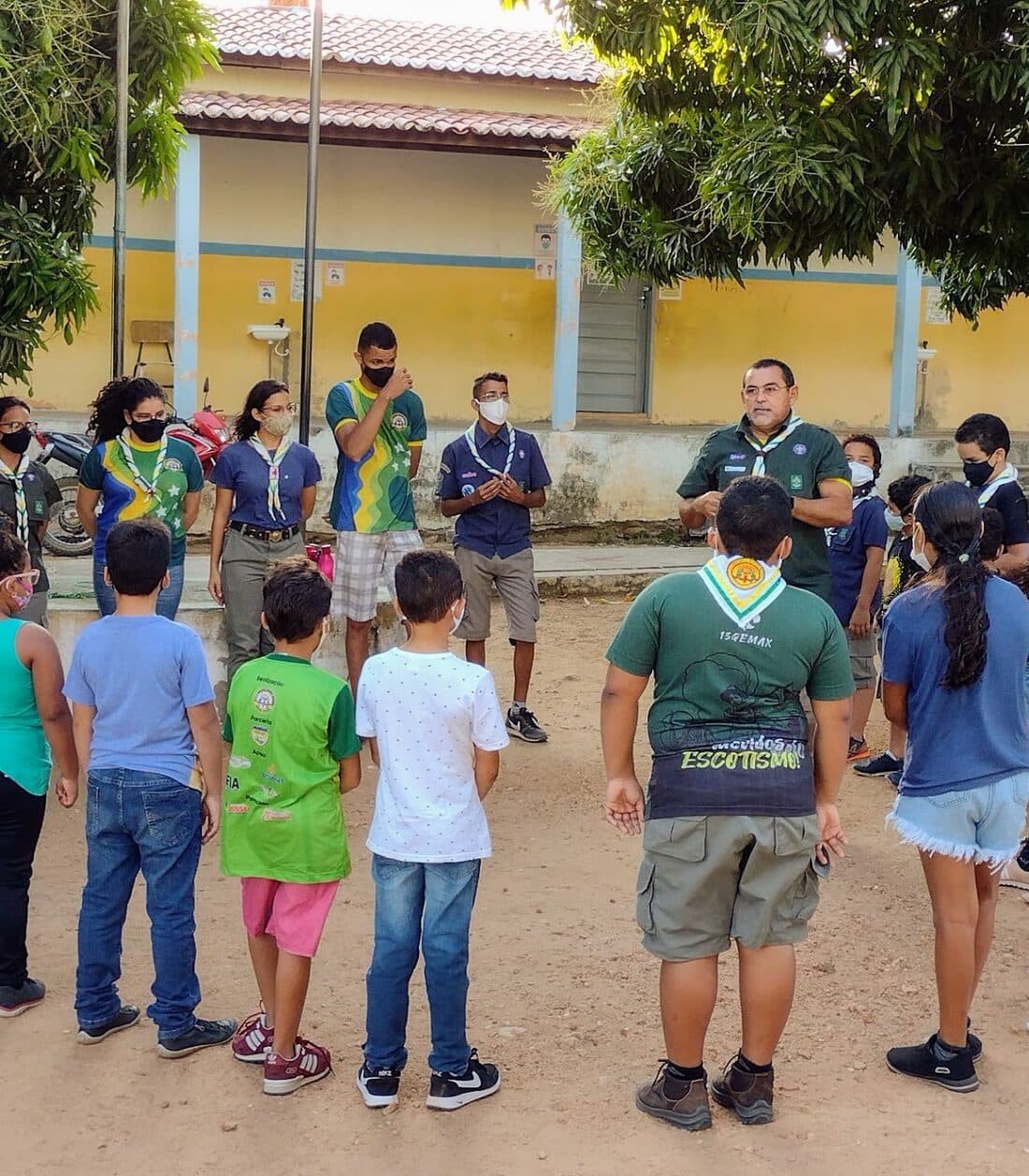 Crianças, jovens e adultos do 13º GEMBM reunidos em uma atividade na sede.